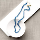 Blue kyanite knotted gem necklace in a white dish