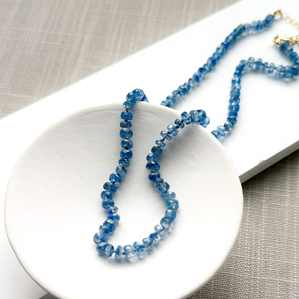 Blue kyanite knotted gem necklace in a white dish
