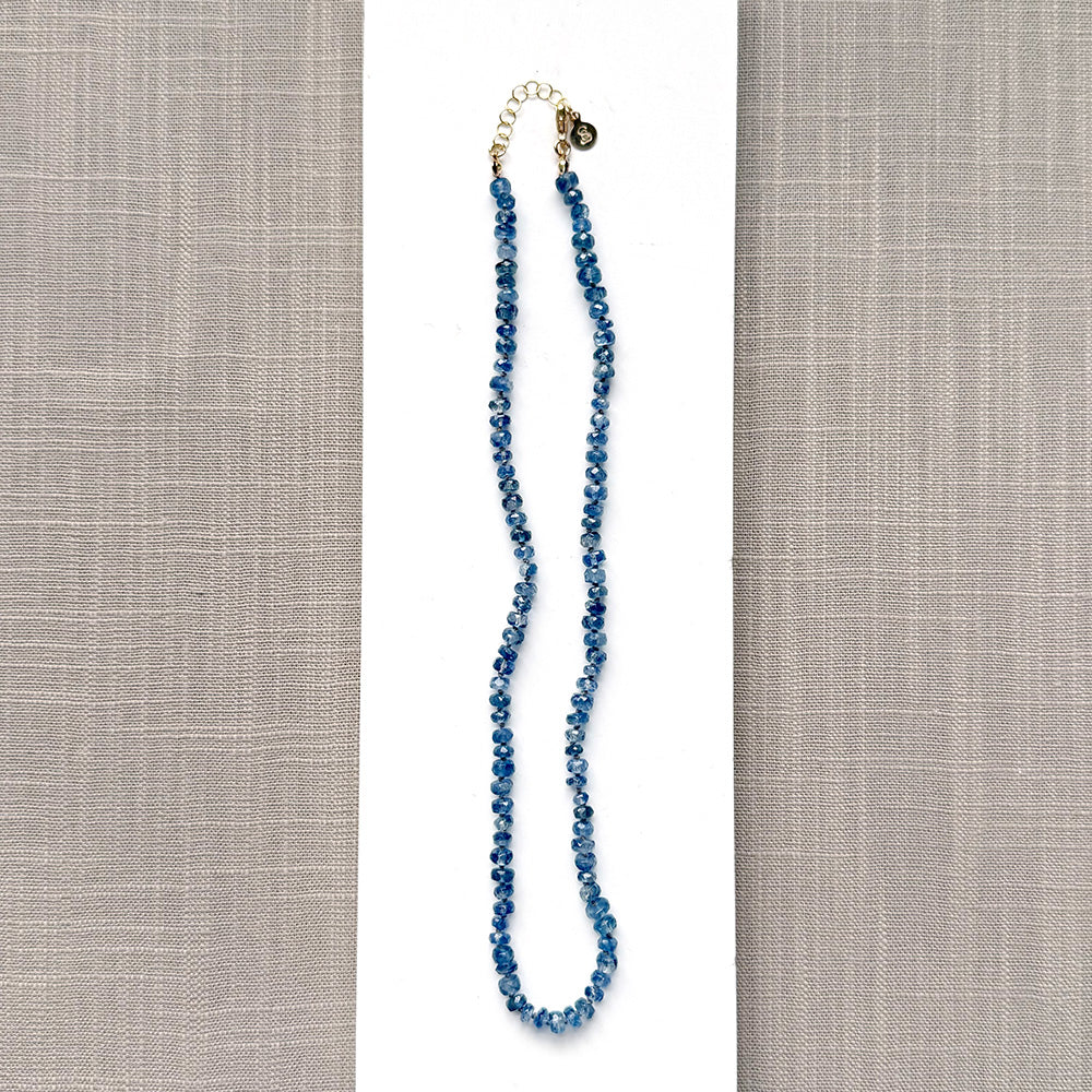 Blue kyanite knotted gem necklace on a white plate