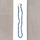 Blue kyanite knotted gem necklace on a white plate