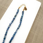 Blue kyanite knotted gem necklace on a white plate