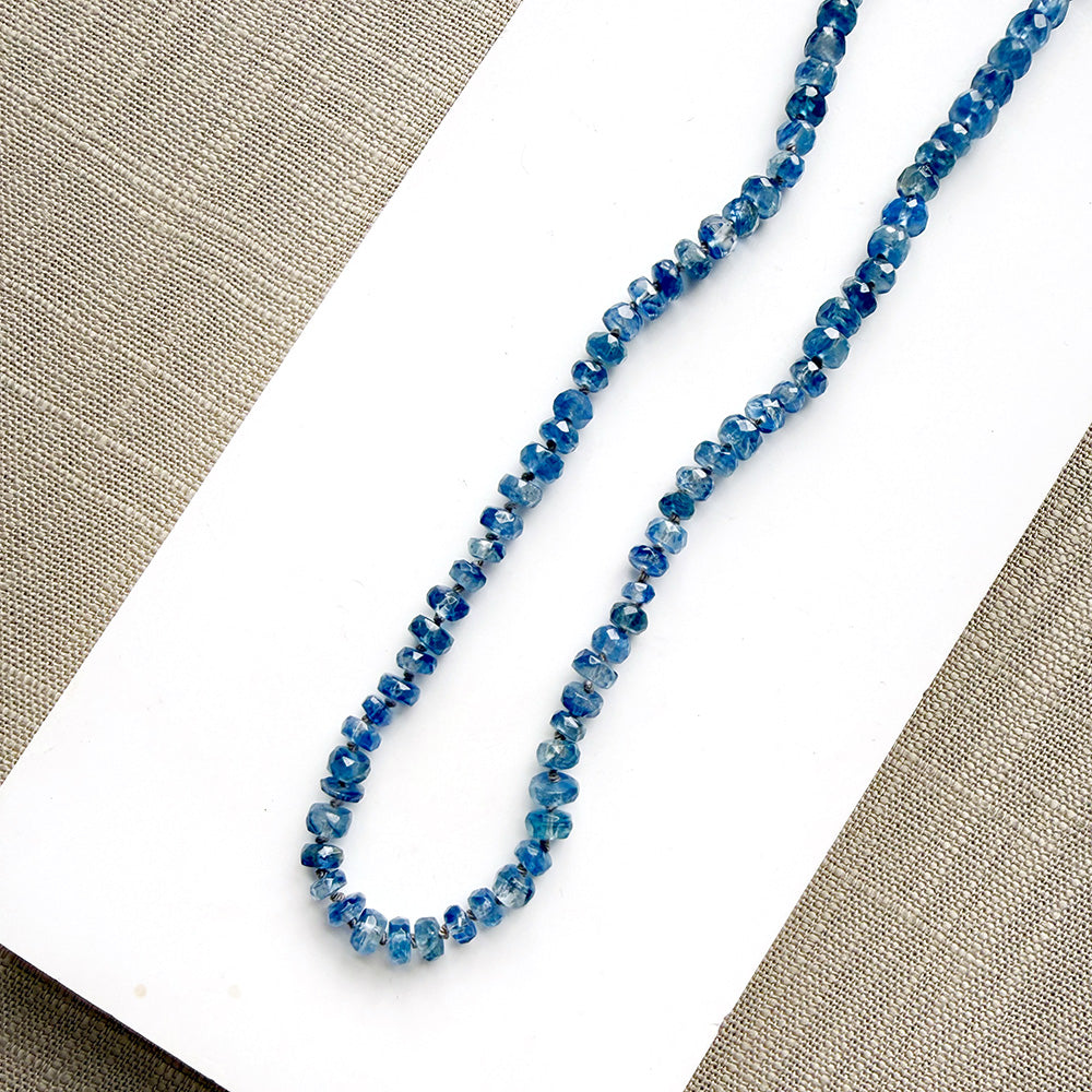 Blue kyanite knotted gem necklace on a white plate