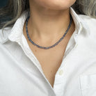 Woman in a white shirt wearing a blue kyanite gemstone necklace