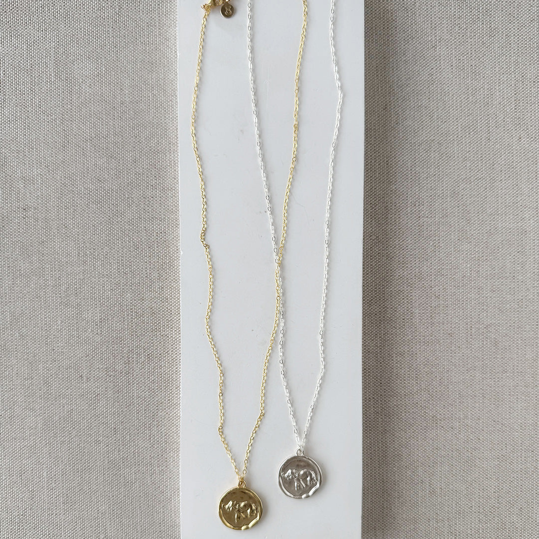 Gold and silver necklaces with round elephant pendants