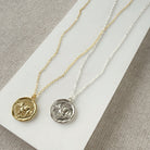 Gold and silver necklaces with round elephant pendants