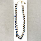 Multi strand necklace with kyanite and smokey quartz on a white plate