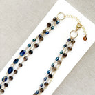 Multi strand necklace with kyanite and smokey quartz on a white plate