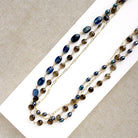 Multi strand necklace with kyanite and smokey quartz on a white plate