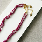Clasp and extender for small ruby gems knotted necklace on a light gray background