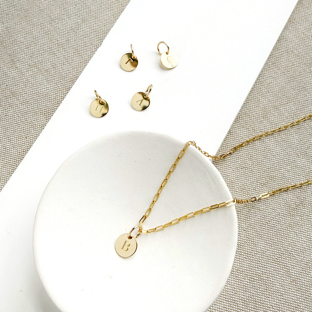 Engraved initial disc charm on a gold chain