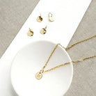 Engraved initial disc charm on a gold chain