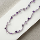 Gemstone necklace in shades of purple on a white surface