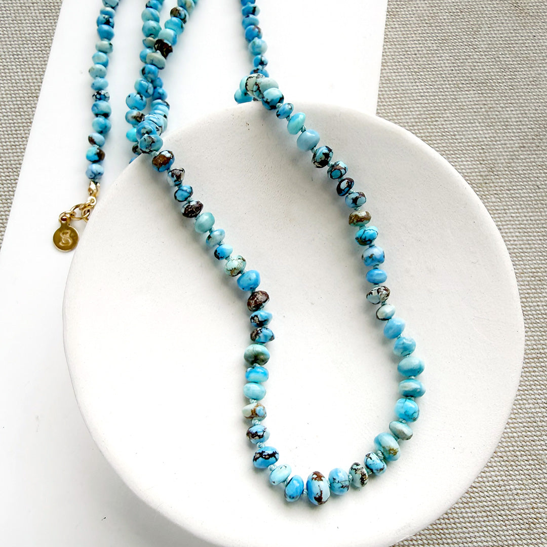 Golden Hills turquoise beaded necklace on a white dish with a neutral background