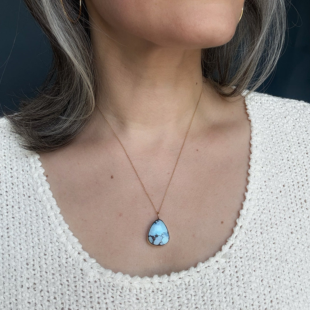 Golden Hills turquoise pendant necklace worn by a person in a white sweater.