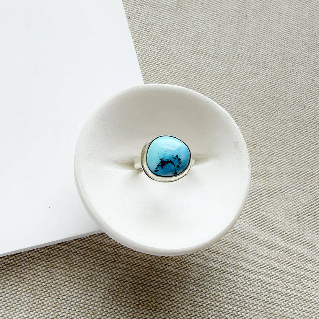 One of a kind Golden Hills Turquoise silver ring in a white dish