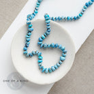 Golden Hill turquoise knotted necklace on a white dish with 'One of a Kind' branding.
