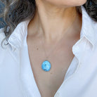 Woman wearing Golden Hills Pendant set in sterling silver with a white shirt