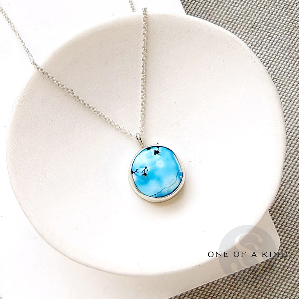 Small Golden Hills pendant set in sterling silver in a white dish