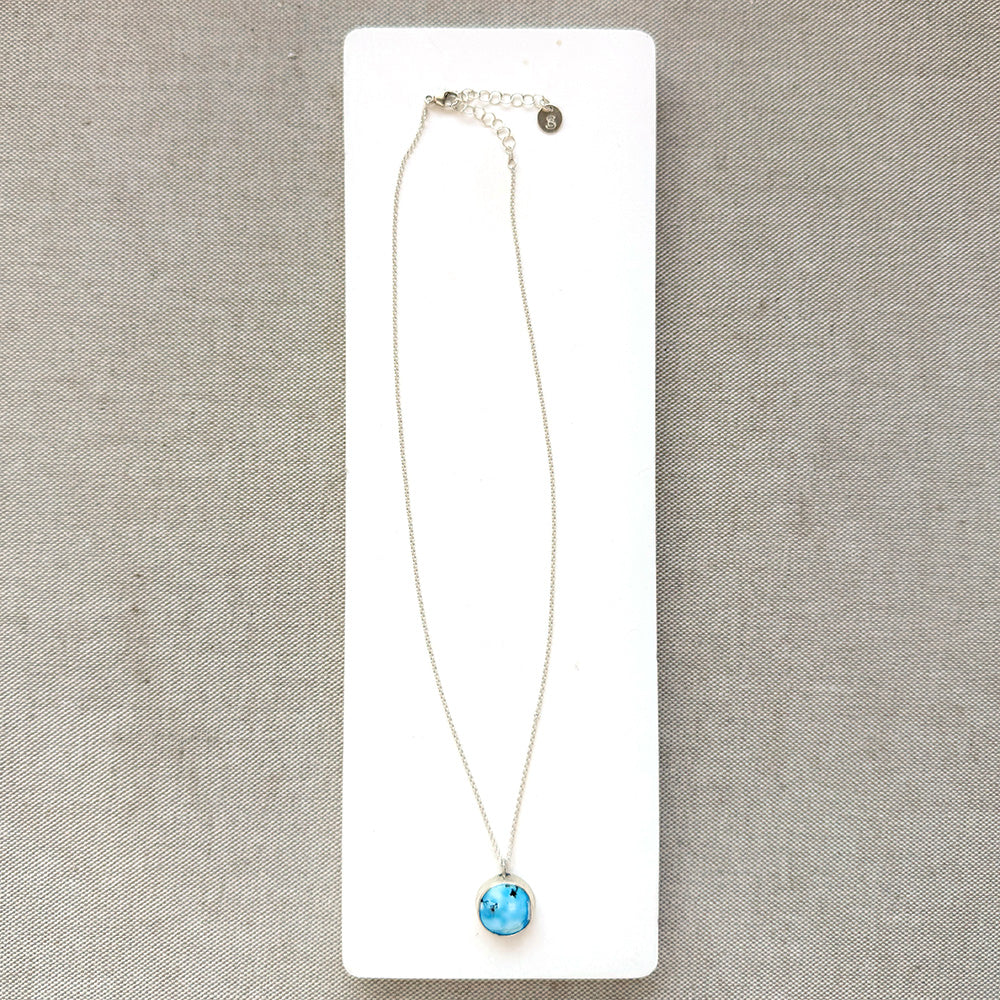 Small Golden Hills pendant set in sterling silver in a white dish