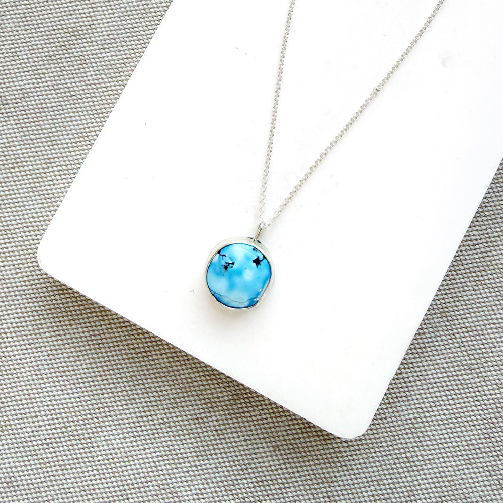 Small Golden Hills pendant set in sterling silver in a white dish