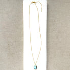 Small oval Golden Hills Pendant set in solid gold on a white plate