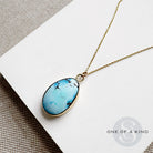A Golden Hills turquoise pendant necklace on a white card with 'One of a Kind' branding.