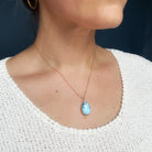 Necklace with a Golden Hills turquoise pendant worn by a person against a dark background