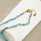 Clasp detail of Golden Hills Turquoise knotted necklace on a white plate