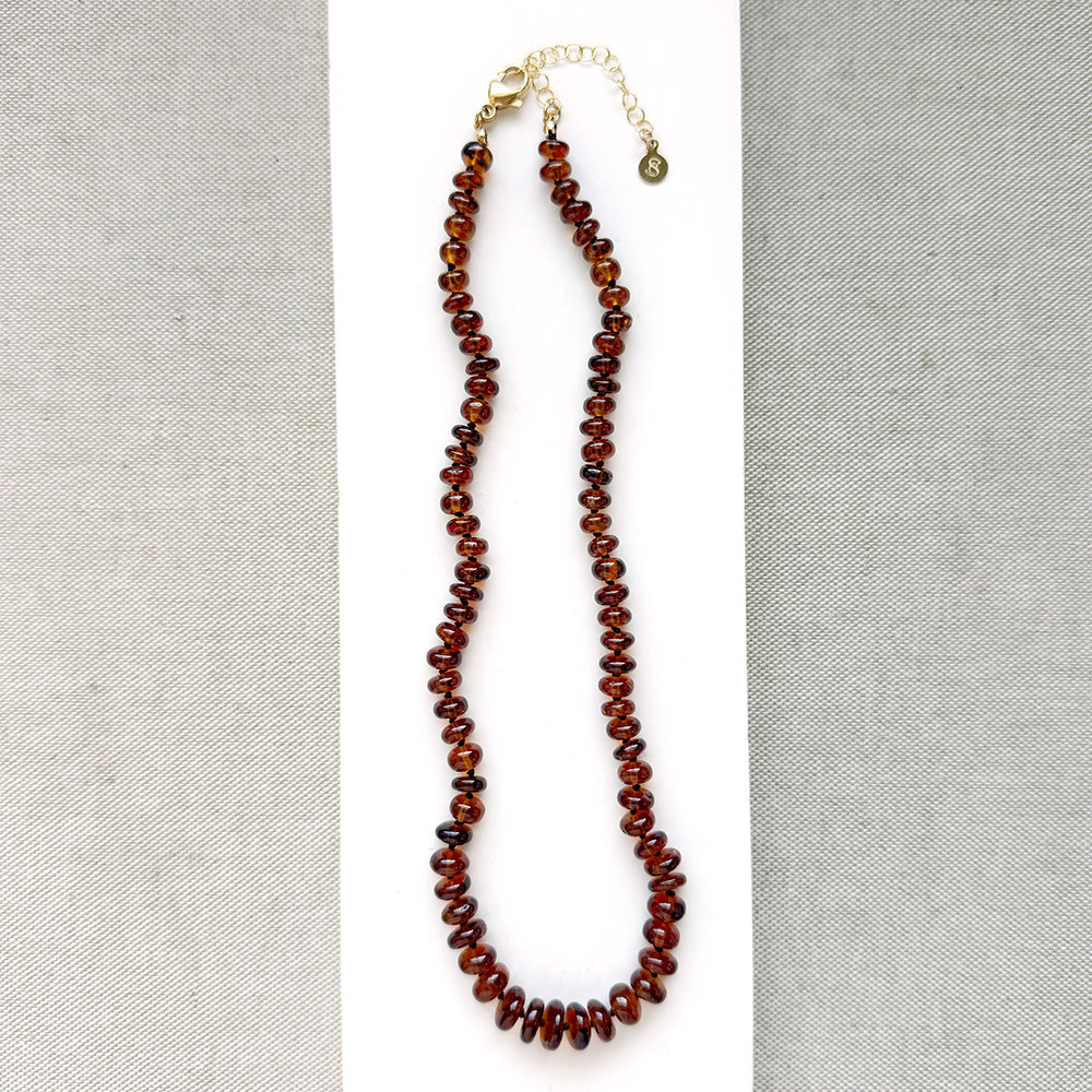Hessonite garnet necklace on a white plate