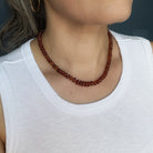Woman wearing a white tank and Hessonite garnet necklace 