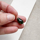 Hand holding a large green tourmaline gemstone charm