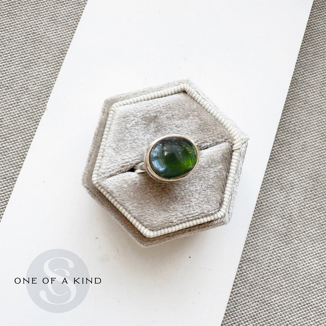 Ring with a green tourmaline gemstone in a hexagonal box and one of a kind branding