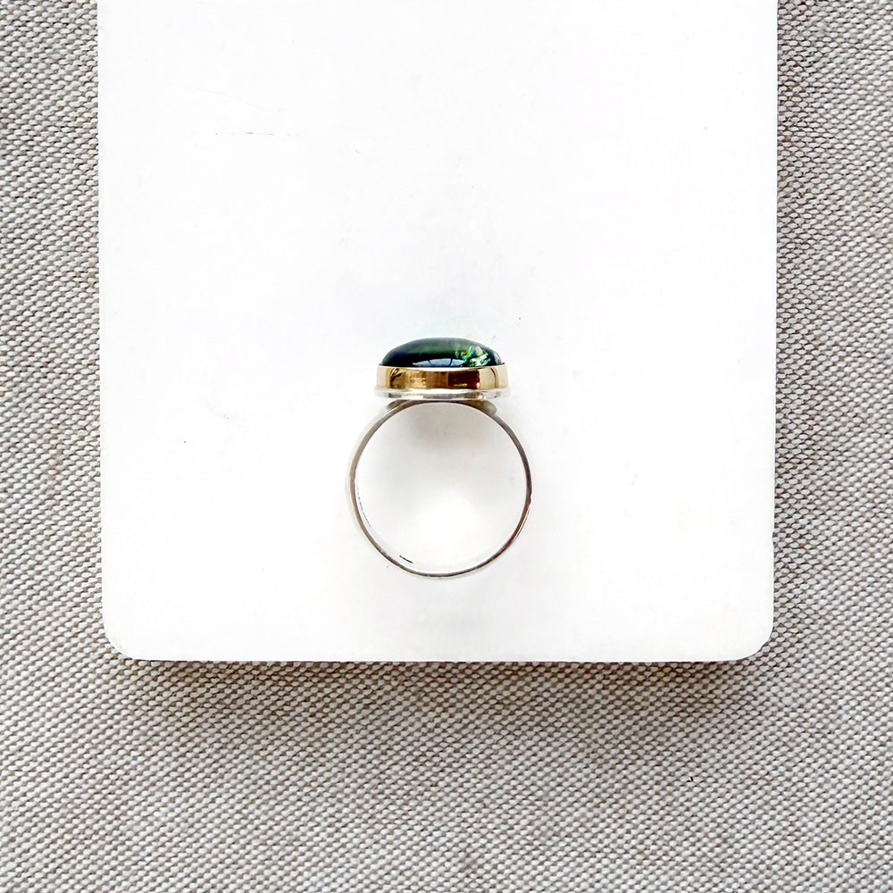Green Tourmaline mixed metal ring on a white background