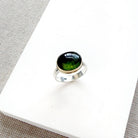 Green Tourmaline mixed metal ring on a white background