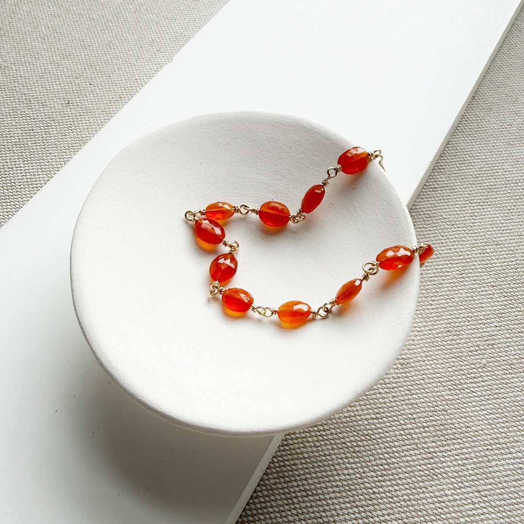 Bracelet with carnelian gemstones in a white dish