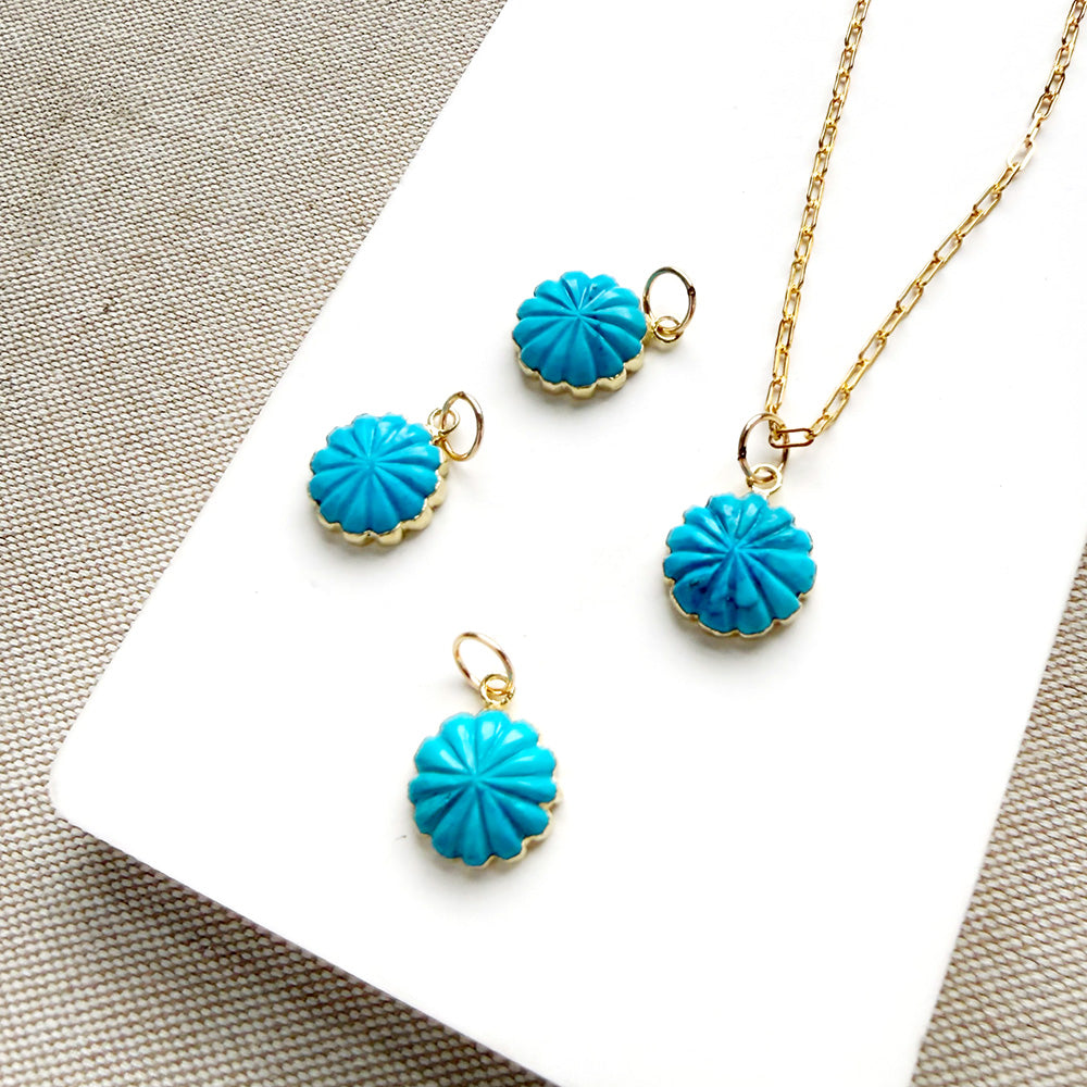 Small carved howlite flower charms on a white background