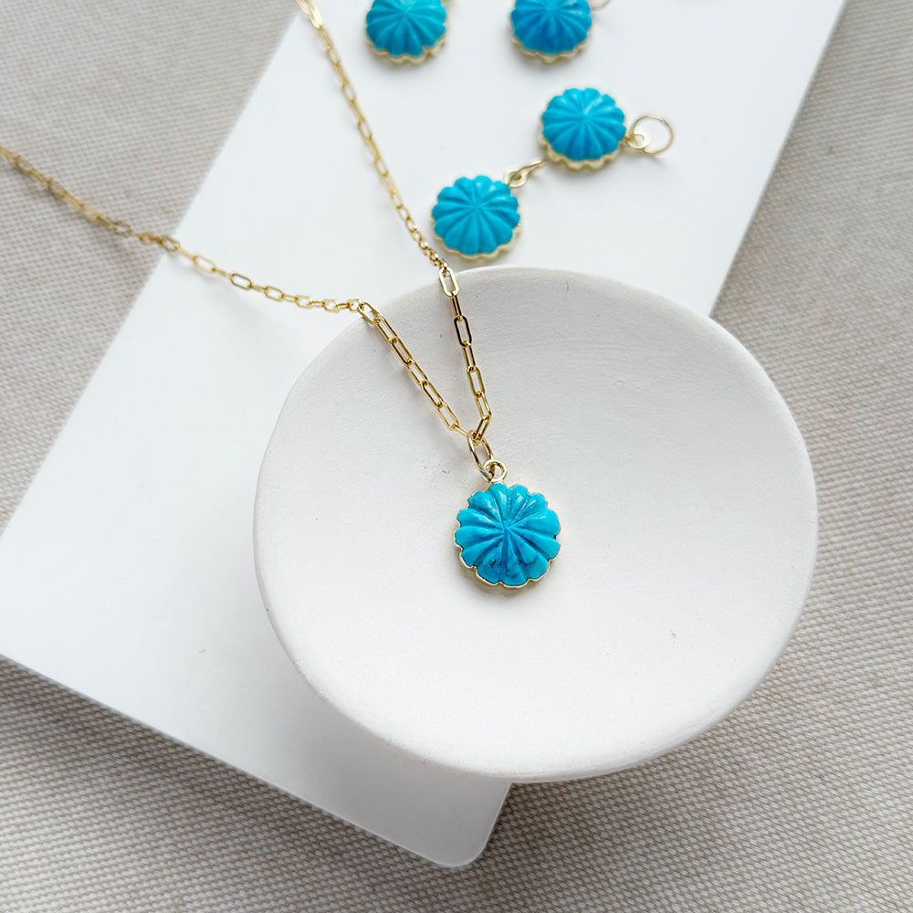 Small carved howlite flower charms on a white background