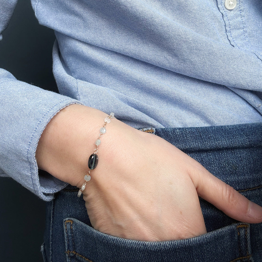 Close up of person wearing an aquamarine and kyanite bracelet