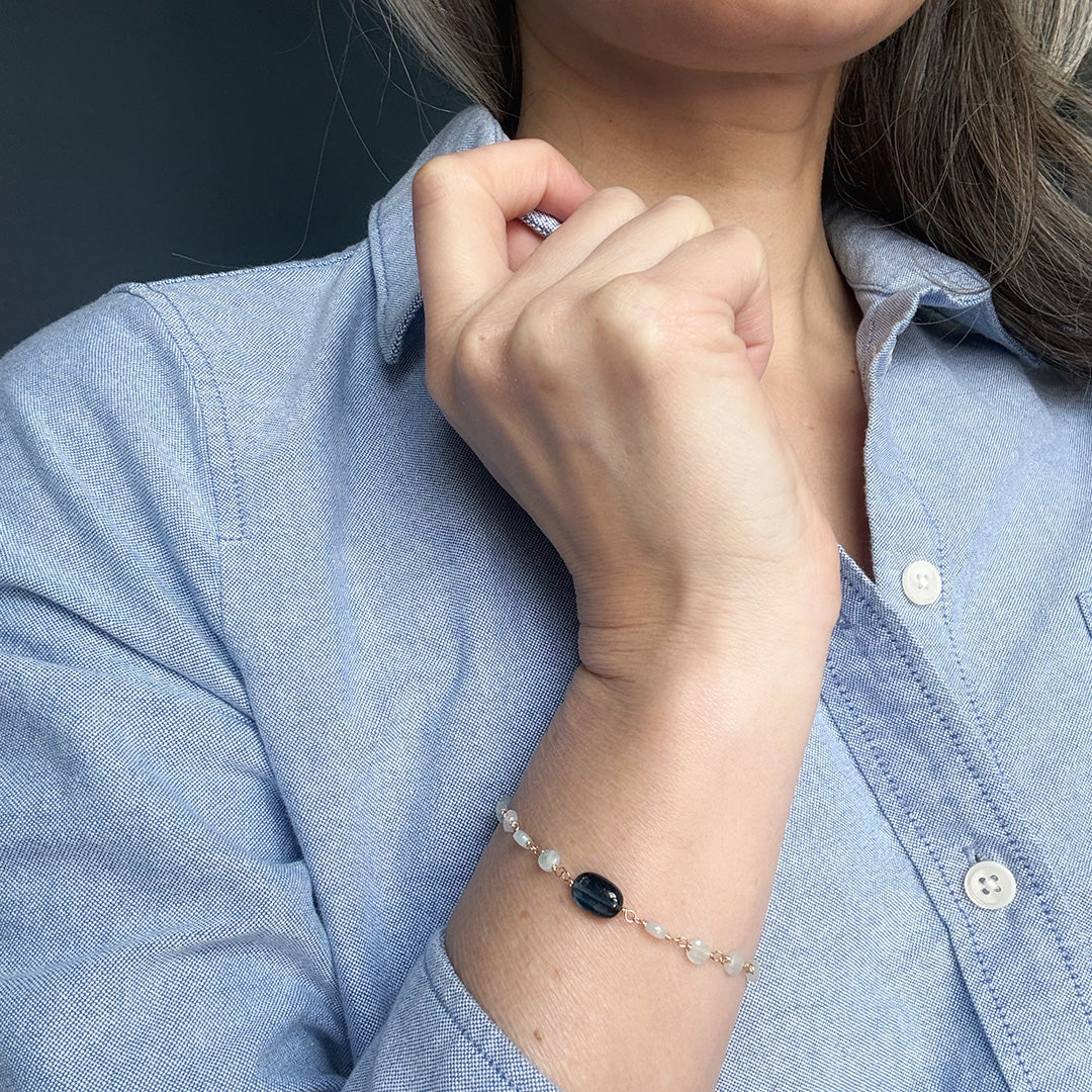 Close up of person wearing an aquamarine and kyanite bracelet