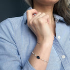 Close up of person wearing an aquamarine and kyanite bracelet