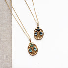 Two gold beetle-shaped pendant necklaces with blue gemstone accents, displayed on a white card over a textured beige fabric background.