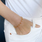 Woman wearing Imperial topaz bracelet on a blue background