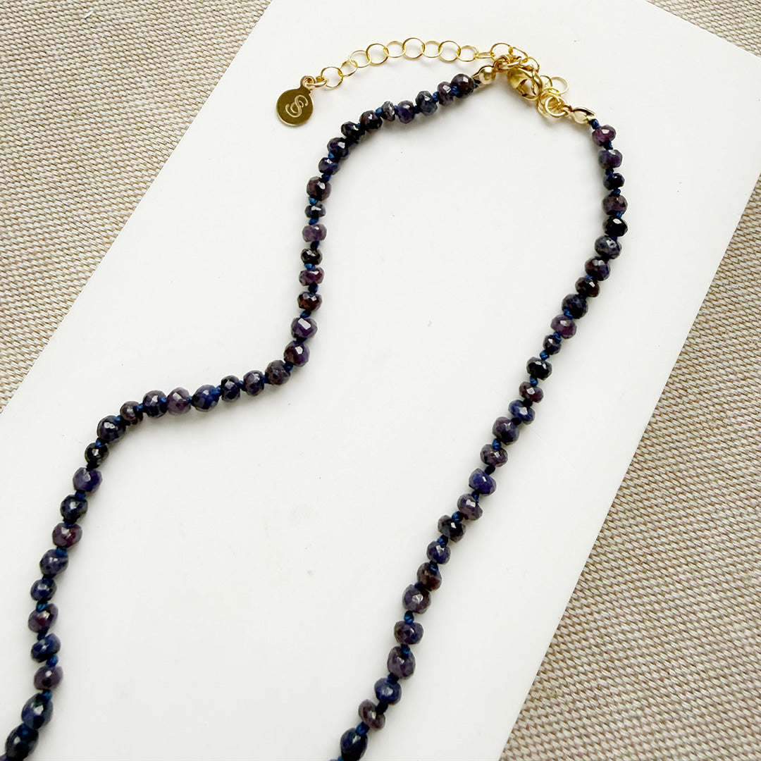 Clasp detail of pendant with purple gemstone knotted necklace