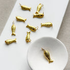 Small gold fish charm in a white dish