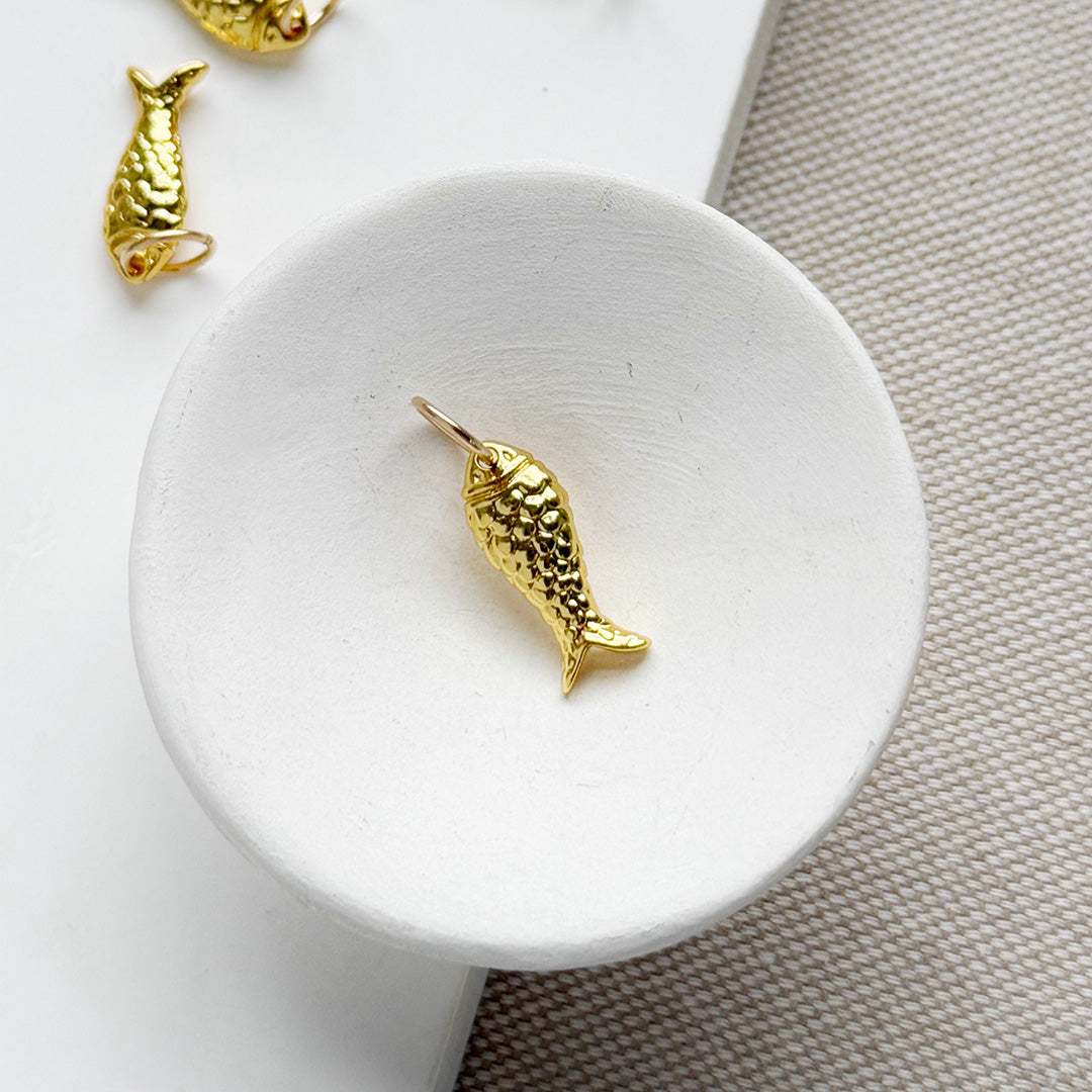 Small gold fish charm in a white dish