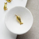 Small gold fish charm in a white dish