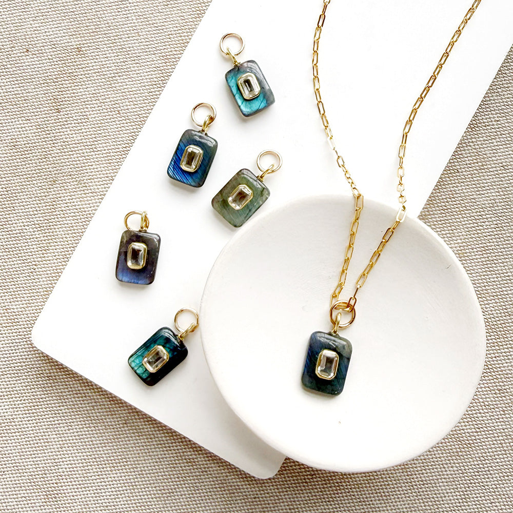 Rectangular labradorite charm with inset cz stone in a white dish