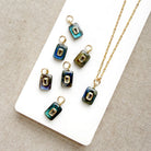Rectangular labradorite charm with inset cz stone on a white dish
