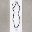 Knotted labradorite necklace with flower shaped carved mother of pearl pendant