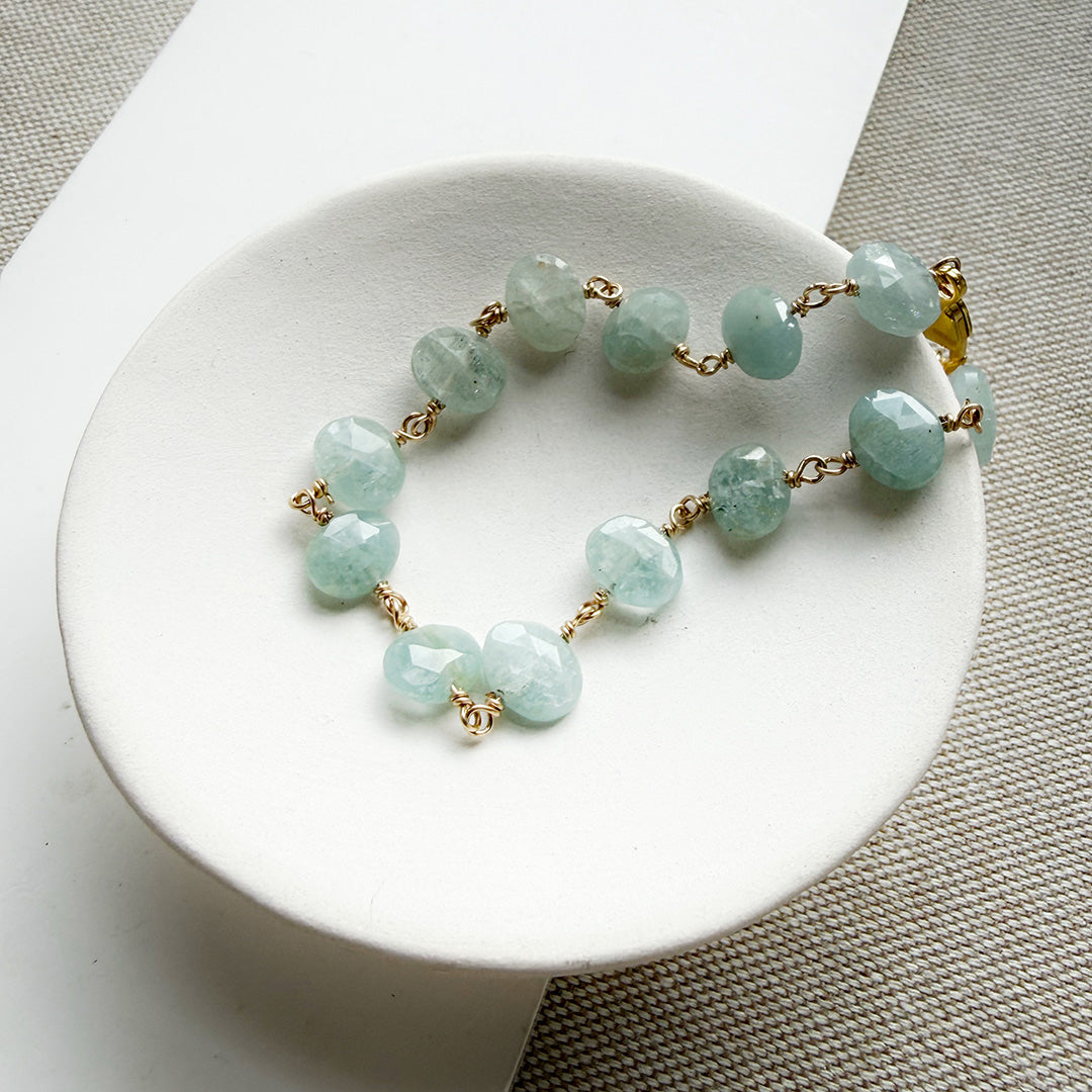 Aquamarine bracelet with gold clasp in a white dish